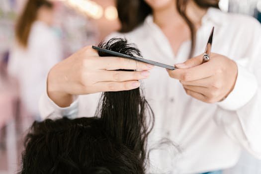 Coiffeuse coupant les cheveux d’une cliente dans un salon de beauté – gestion des rendez-vous en ligne avec Resalib